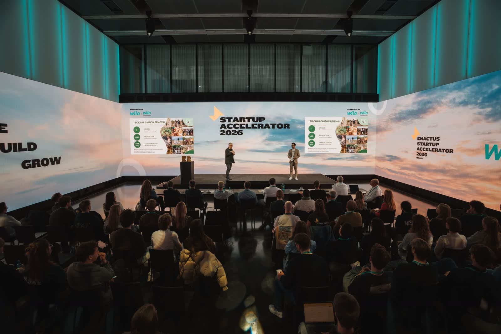 Vortrag auf der Bühne beim Enactus Startup Accelerator, davor das Publikum im Saal